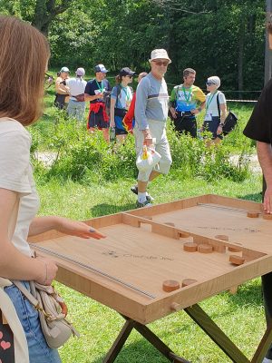 Doi tineri se înfruntă într-un joc de Puc Gigant pe o masă de lemn, în cadrul Brașov Heroes