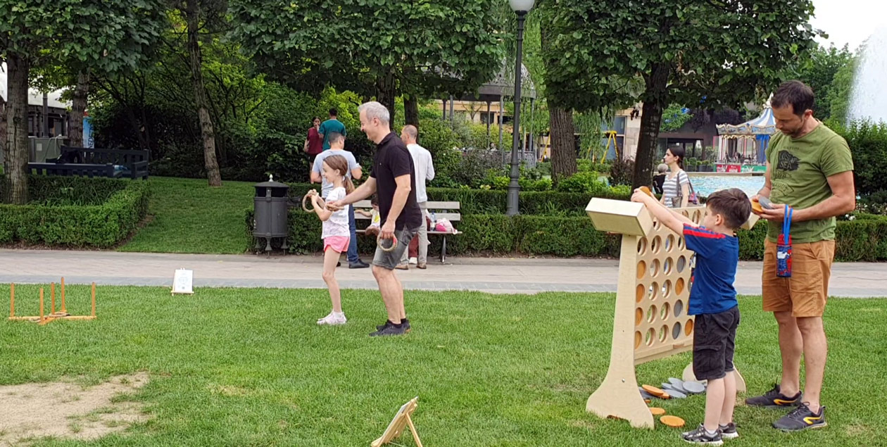 Tată și fiică la Aruncarea Inelelor, în timp ce alt tată și fiu joacă Connect 4 uriaș în Grădinile Palas, în cadrul evenimentului Chef de Joc