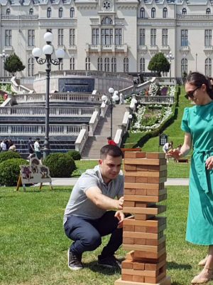 Doi tineri jucând Jenga uriașă în fața Palatului Culturii din Iași, în cadrul Festivalului Sporturilor cu Chef de Joc