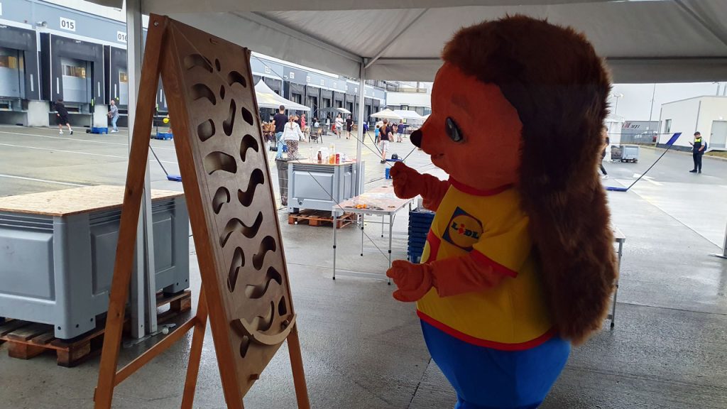 Mascota LIDL jucându-se la jocuri gigantice din lemn la eveniment corporate family day - teambuilding outdoor România