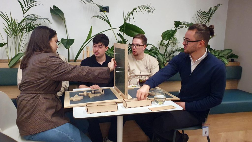 Patru angajați concentrați la joc de strategie din lemn petrecere corporate Crăciun București