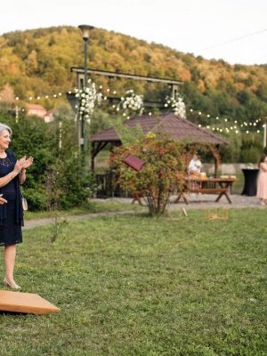 Nuntași eleganti jucând Cornhole în grădină la nuntă