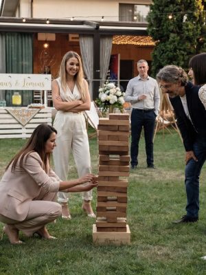 Grup de nuntași jucând Jenga gigant în exterior la nuntă