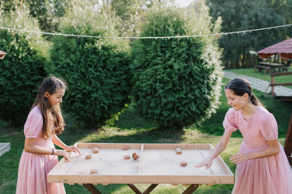 Girls playing puc wooden game at a wedding