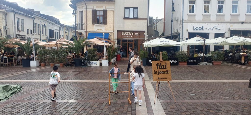 Panou Chef de Joc Hai la joacă în Piața centrală Craiova pe timp de ploaie, Shakespeare Festival 2026