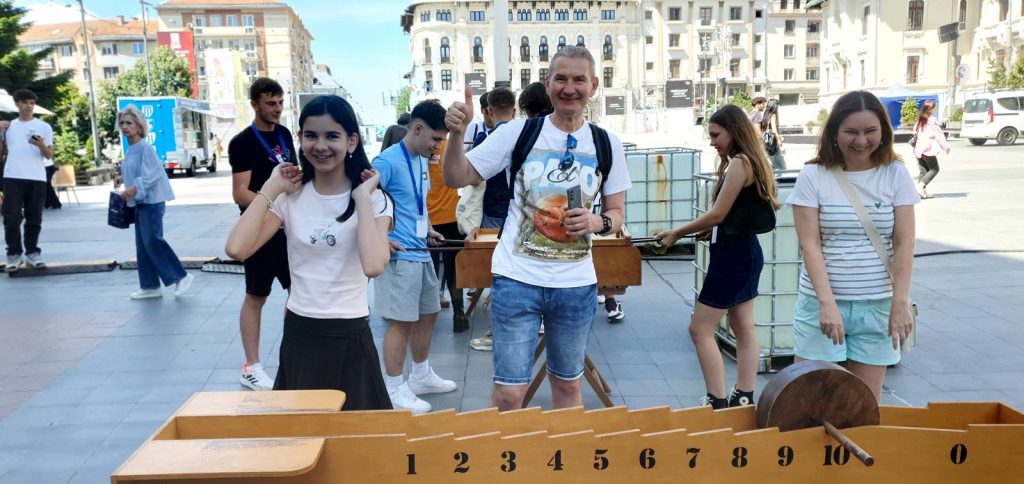 Trei participanți fericiți la jocuri din lemn Chef de Joc în Piața Mihai Viteazul Craiova, ultima zi a Shakespeare Festival 2026