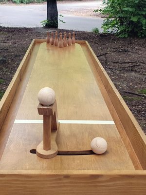 Mini bowling din lemn masiv montat în aer liber, cu braț de lansare și popice la capătul pistei